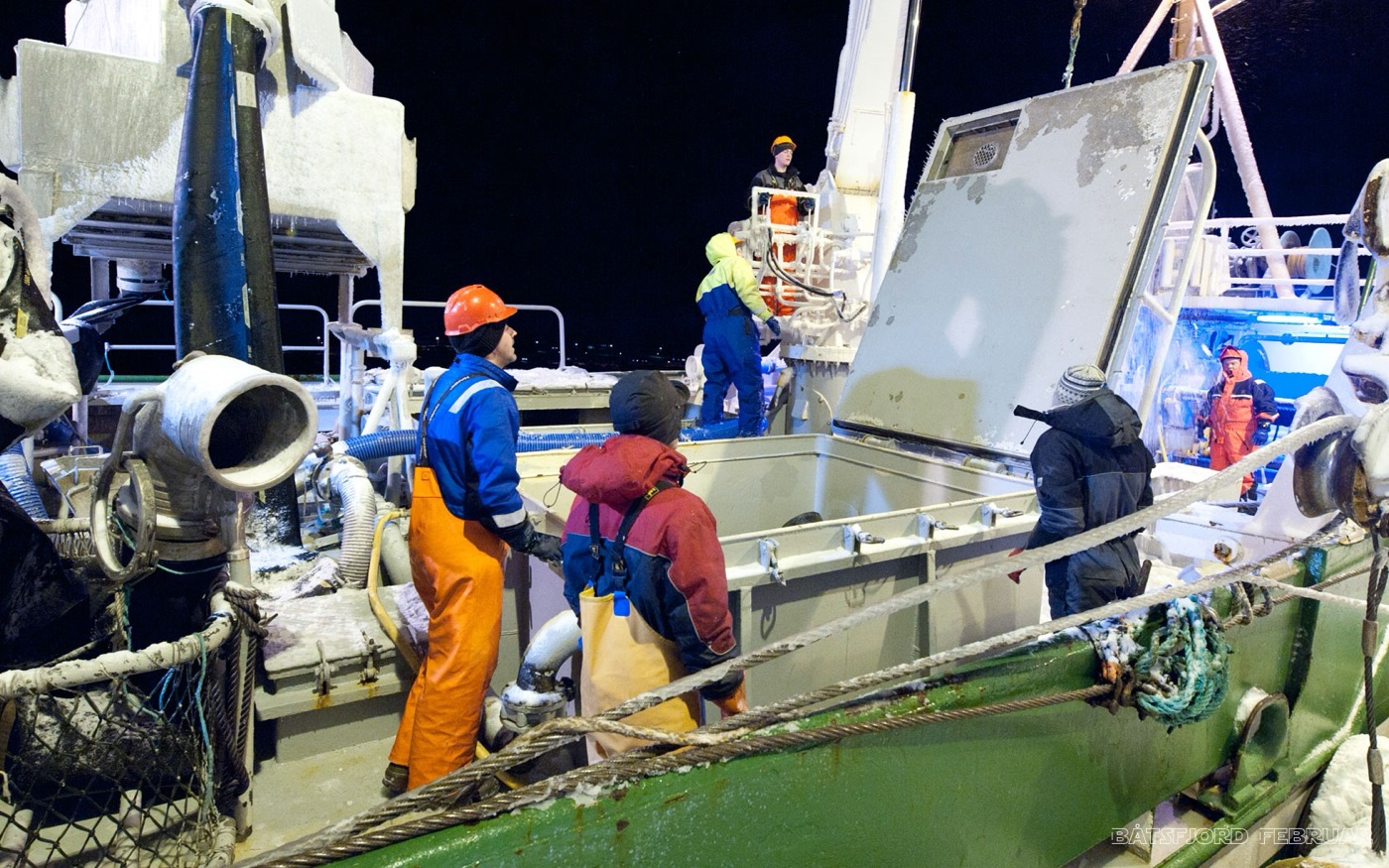 Fiskere i arbeid om bord på en fiskebåt i mørketiden